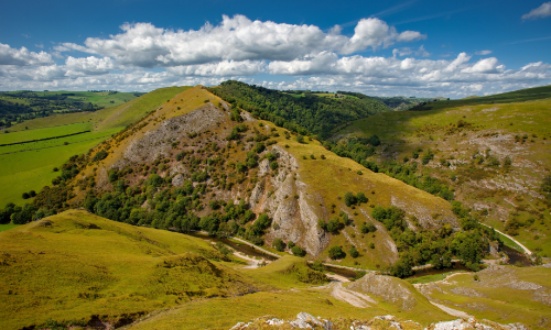 Dovedale-thorpecloud A scenic view of Thorpe Cloud, the iconic limestone hill in Dovedale, Peak District, overlooking the green valley and river